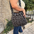 Sac Noly Tube crochété main coloris Asphalte porté à l'épaule, gros plan sur la maille XXL et l'anse tressée — Noly Yarn